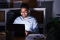 Hispanic man with beard working at the office with laptop at night looking positive and happy standing and smiling with a Royalty Free Stock Photo