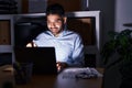 Hispanic man with beard working at the office with laptop at night smiling happy pointing with hand and finger Royalty Free Stock Photo