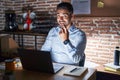 Hispanic man with beard working at the office at night beckoning come here gesture with hand inviting welcoming happy and smiling Royalty Free Stock Photo