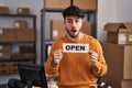 Hispanic man with beard working at small business ecommerce holding open sign afraid and shocked with surprise and amazed Royalty Free Stock Photo