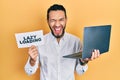 Hispanic man with beard working using computer laptop holding lazy loading banner smiling and laughing hard out loud because funny Royalty Free Stock Photo