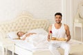 Hispanic Man Bring Breakfast To Sleeping Woman In Morning Tray With Red Rose Flower, Young Couple Royalty Free Stock Photo