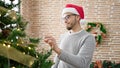 Hispanic man decorating christmas tree at home Royalty Free Stock Photo