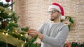 Hispanic man decorating christmas tree at home Royalty Free Stock Photo