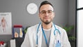 Hispanic man doctor with serious expression at the clinic