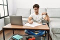 Hispanic man doing papers at home pointing down looking sad and upset, indicating direction with fingers, unhappy and depressed Royalty Free Stock Photo