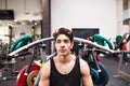 Hispanic man in gym prepared for training on fitness machine.