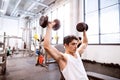 Hispanic man in gym sitting on bench, working out with weights Royalty Free Stock Photo