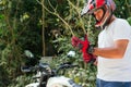 Hispanic man with helmet putting on gloves before taking a motorcycle ride in the countryside in summer