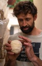 Hispanic man holding lion mane mushroom outdoors