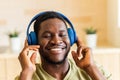 hispanic man listening music in wireless headphones at home Royalty Free Stock Photo