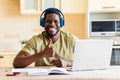 hispanic man listening music in wireless headphones and working by laptop at home Royalty Free Stock Photo