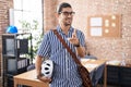 Hispanic man with long hair working at the office holding bike helmet pointing fingers to camera with happy and funny face Royalty Free Stock Photo