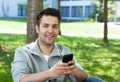Hispanic man outside in a park sending message Royalty Free Stock Photo