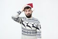 Hispanic man in red christmas cap thinking deeply about gifts, looking at camera Royalty Free Stock Photo