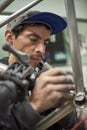 Hispanic man removing paint residue from a bike frame at his workshop Royalty Free Stock Photo