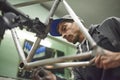 Hispanic man sanding a bicycle frame at his workshop