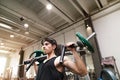 Hispanic man training in gym, doing machine shoulder press.