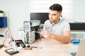 Hispanic man using a screwdriver to fix the pc hardware