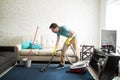 Hispanic man vacuuming the living room Royalty Free Stock Photo