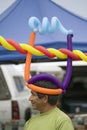 A Hispanic man wares multi-colored balloons