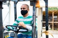 Hispanic man driving a forklift truck during a pandemic. Royalty Free Stock Photo