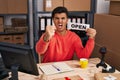 Hispanic man working at small business ecommerce holding open banner annoyed and frustrated shouting with anger, yelling crazy