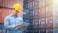 Hispanic manager checking on a tablet at shipping container yard. Royalty Free Stock Photo