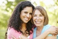 Hispanic Mother And Adult Daughter Relaxing In Park Royalty Free Stock Photo