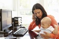 Hispanic mother with baby working in home office Royalty Free Stock Photo