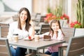 Hispanic mother and daughter hanging out at a restaurant Royalty Free Stock Photo
