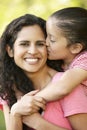 Hispanic Mother And Daughter Relaxing In Park