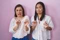 Hispanic mother and daughter together disgusted expression, displeased and fearful doing disgust face because aversion reaction Royalty Free Stock Photo