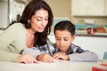 Hispanic Mother Helping Son With Homework At Table Royalty Free Stock Photo