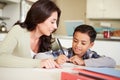 Hispanic Mother Helping Son With Homework At Table Royalty Free Stock Photo