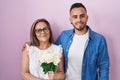 Hispanic mother and son together holding bouquet of white flowers smiling with a happy and cool smile on face Royalty Free Stock Photo