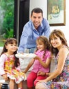 Hispanic parents with two daughters eating from a Royalty Free Stock Photo