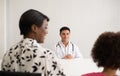 Hispanic physician meeting and diagnosis mixed-race afro children with her African American mother at a hospital. Royalty Free Stock Photo