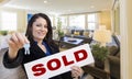 Hispanic Realtor with Keys and Sold Sign in Living Room Royalty Free Stock Photo
