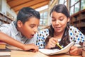 Hispanic School Kids Doing Homework Together in the Library Royalty Free Stock Photo