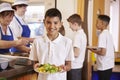 Hispanic schoolboy holds a plate of food in school cafeteria Royalty Free Stock Photo
