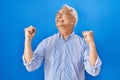 Hispanic senior man wearing glasses celebrating surprised and amazed for success with arms raised and eyes closed Royalty Free Stock Photo