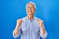 Hispanic senior man wearing glasses excited for success with arms raised and eyes closed celebrating victory smiling Royalty Free Stock Photo