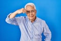 Hispanic senior man wearing glasses pointing unhappy to pimple on forehead, ugly infection of blackhead Royalty Free Stock Photo