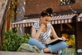 Hispanic serious woman reading book while sitting on bench Royalty Free Stock Photo