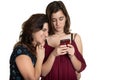 Hispanic teenage girl and her affectionate mother looking at a smartphone