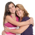 Hispanic teenage girl hugging her mother isolated on white