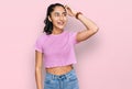 Hispanic teenager girl with dental braces wearing casual clothes smiling confident touching hair with hand up gesture, posing