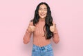 Hispanic teenager girl with dental braces wearing casual clothes success sign doing positive gesture with hand, thumbs up smiling Royalty Free Stock Photo