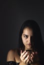 Hispanic teenager playing with a crystal ball on a black background. Mysticism concept Royalty Free Stock Photo